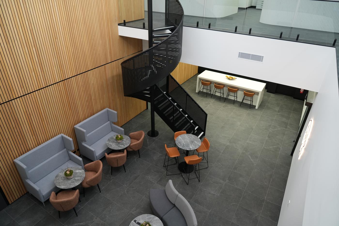The new office's central atrium and breakout space, with a spiral staircase connecting the two levels