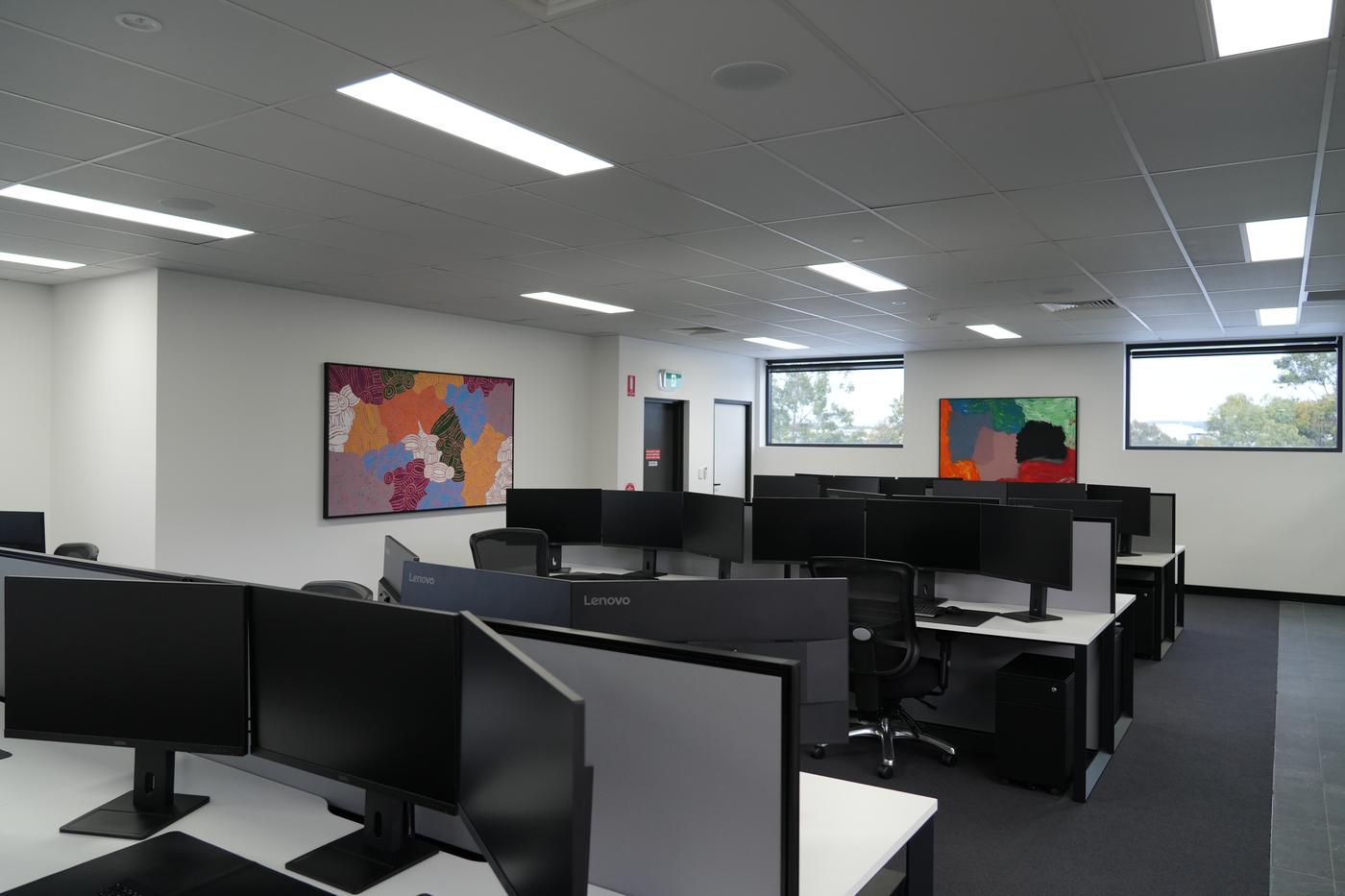 Open-plan workspace in The Advanced Group's new office, featuring colourful Indigenous artwork on the walls